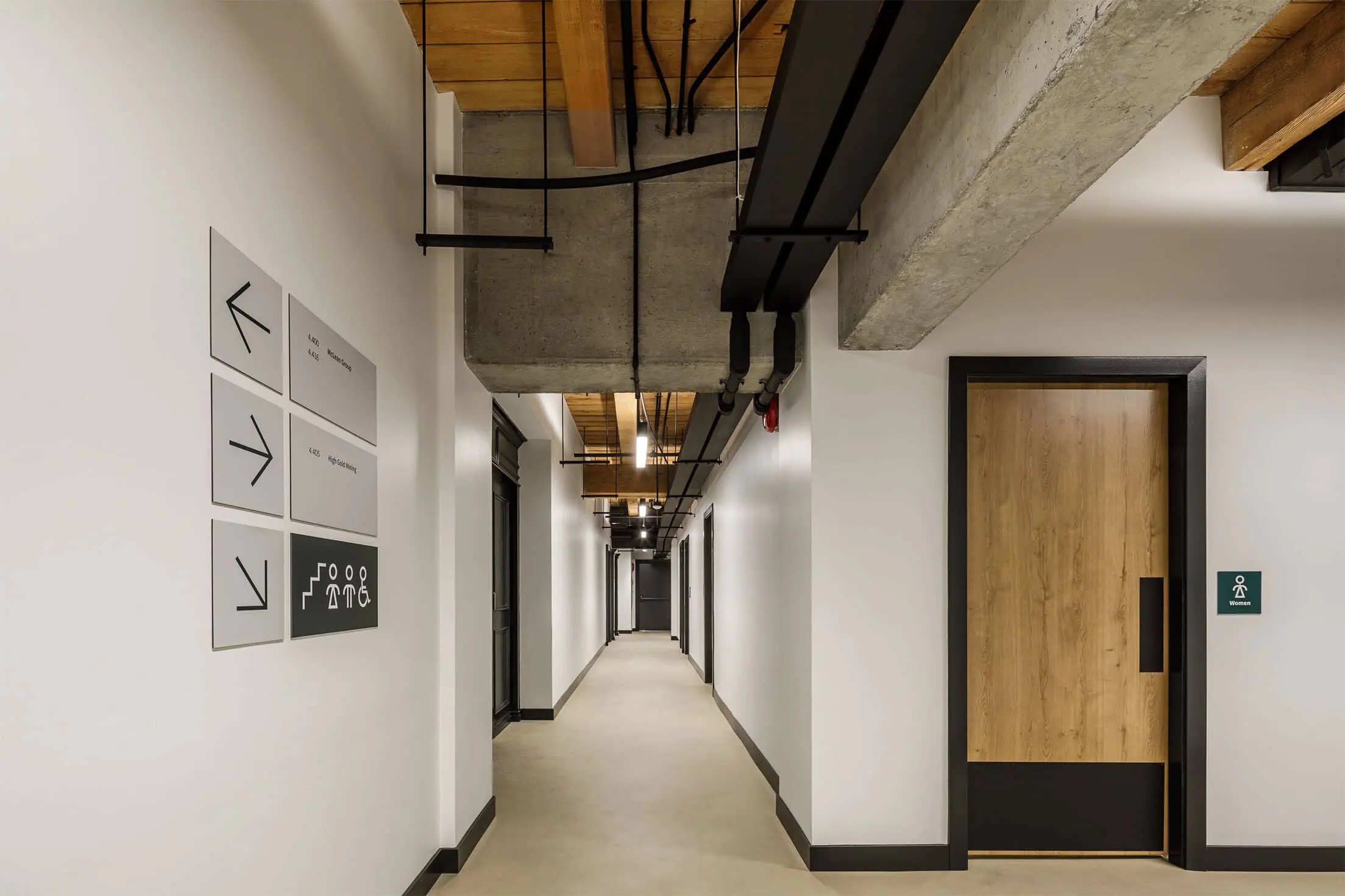 Workspace interior showing sliding wood panel wall, conference room and chairs, and big window looking at Vancouver night sky. Key Marketing office design by Cutler.